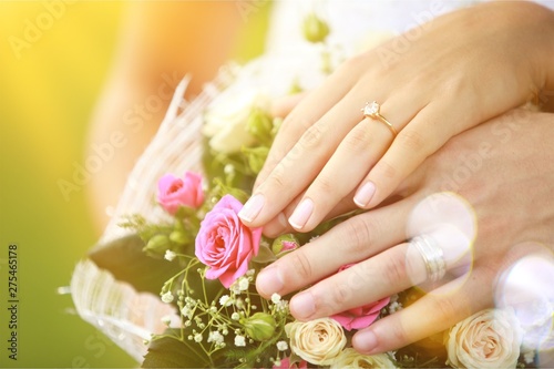 People hands with rings and flowers on background  wedding concept close up