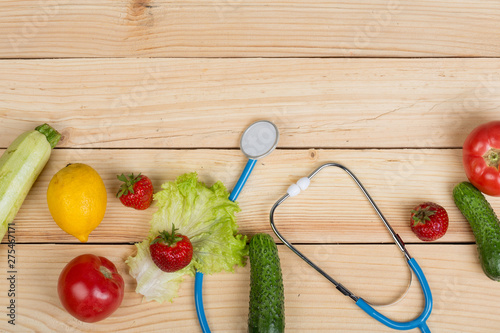 Canvas Print Good healthy and diet concept - stethoscope and vegetables, fruits and berries o
