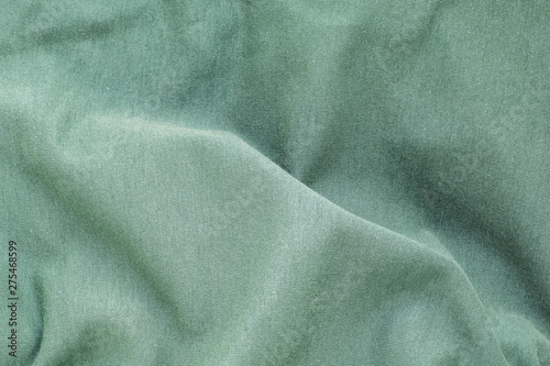 The background texture is a green soft wavy fabric, top view, close-up.