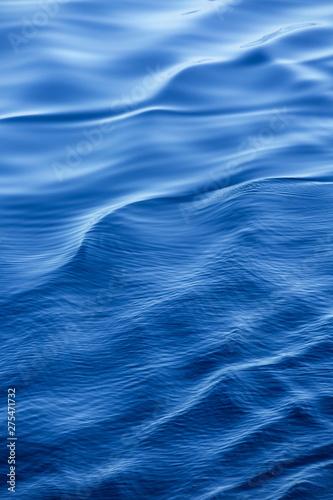 water ripple reflection of a calm wave in the ocean in a soft backlight