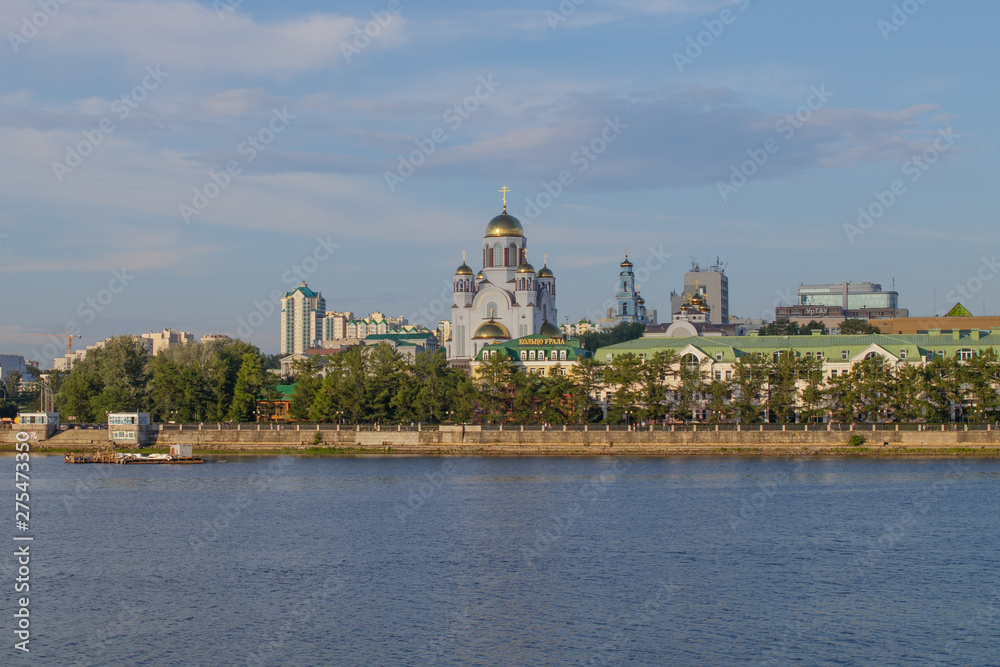 Yekaterinburg. Summer city landscape. View of the River Iset and the Church of the Resplendent in the Russian Land. Yekaterinburg. Summer city landscape. View of the River Iset and the Church of the Resplendent in the Russian Land.
