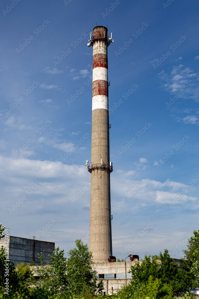 Chimneys of an old factory. Pipes for air emissions. Communication Antennas mounted on old industrial chimney