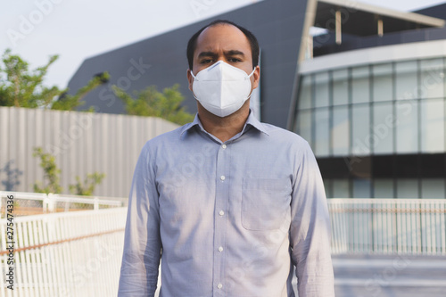 Man wearing facial hygienic mask nose outdoors. Air pollution concept.