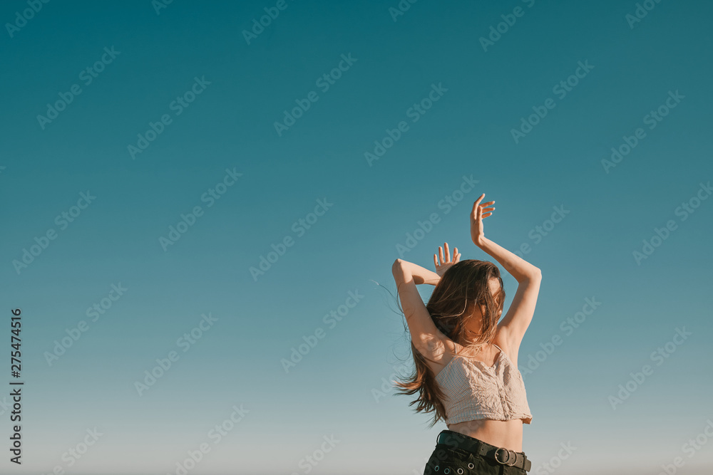 Obraz premium a young woman in a summer day with a blue sky - negative space