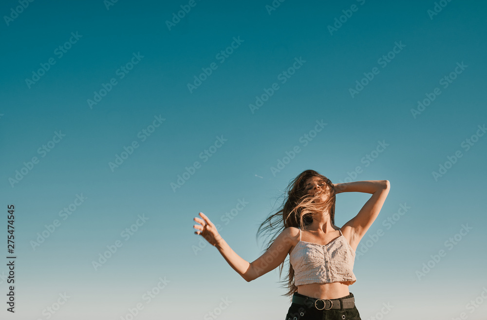 a young woman in a summer day with a blue sky - negative space a young woman in a summer day with a blue sky - negative space