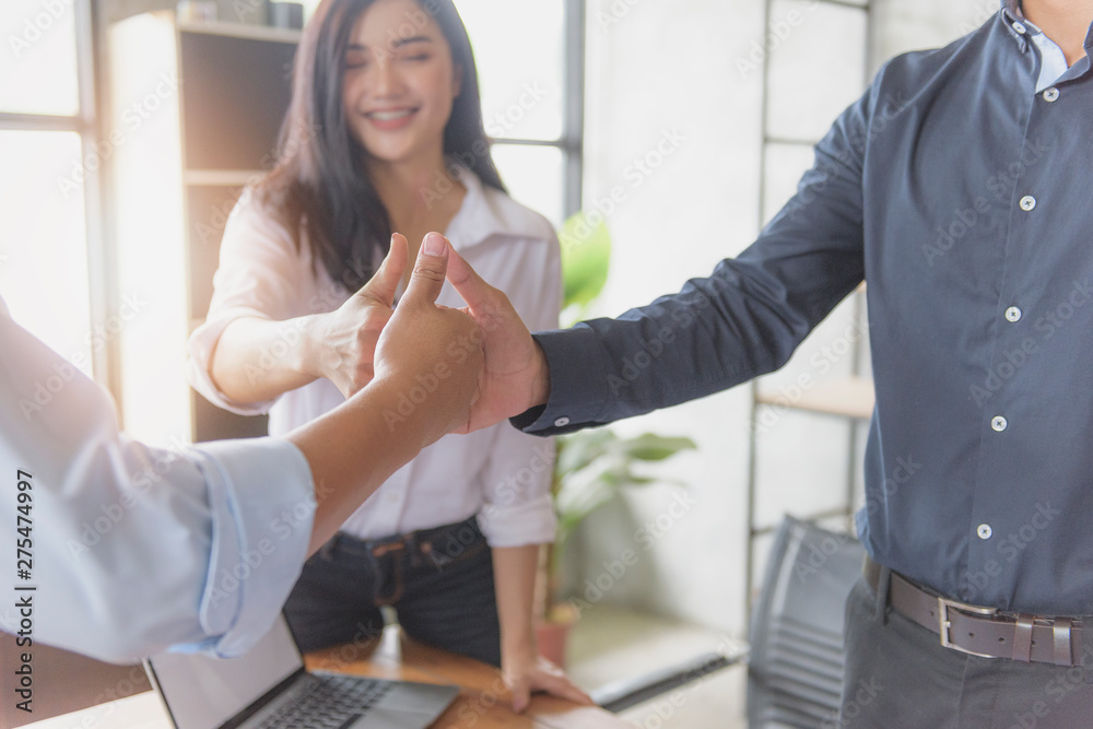 Three business partners keeping thumbs up Three business partners keeping thumbs up