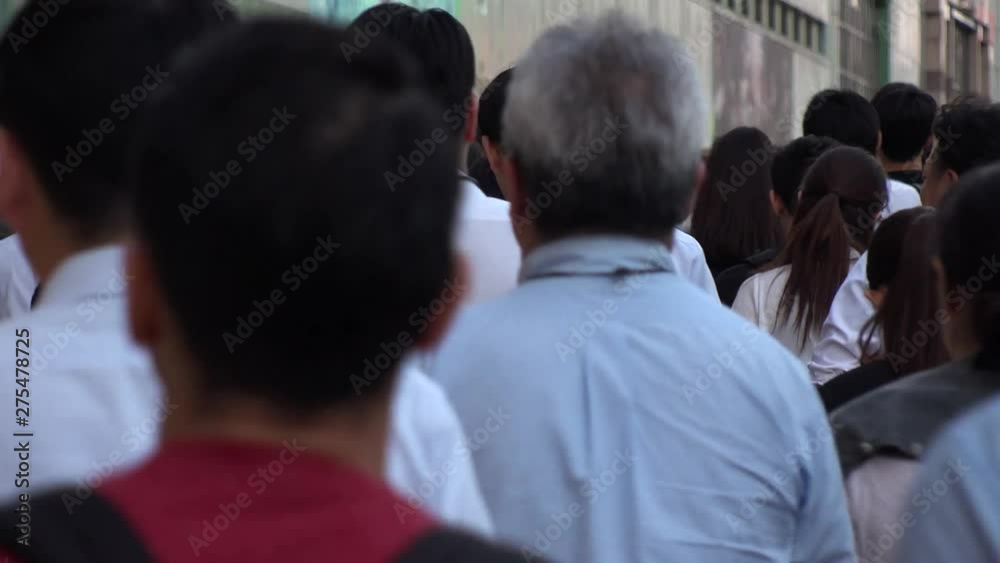 SHINJUKU, TOKYO, JAPAN - CIRCA JUNE 2019 : View of crowd of people walking down the street in busy rush hour. Many commuter walking to the train station after work. Shot in early evening. SHINJUKU, TOKYO, JAPAN - CIRCA JUNE 2019 : View of crowd of people walking down the street in busy rush hour. Many commuter walking to the train station after work. Shot in early evening.