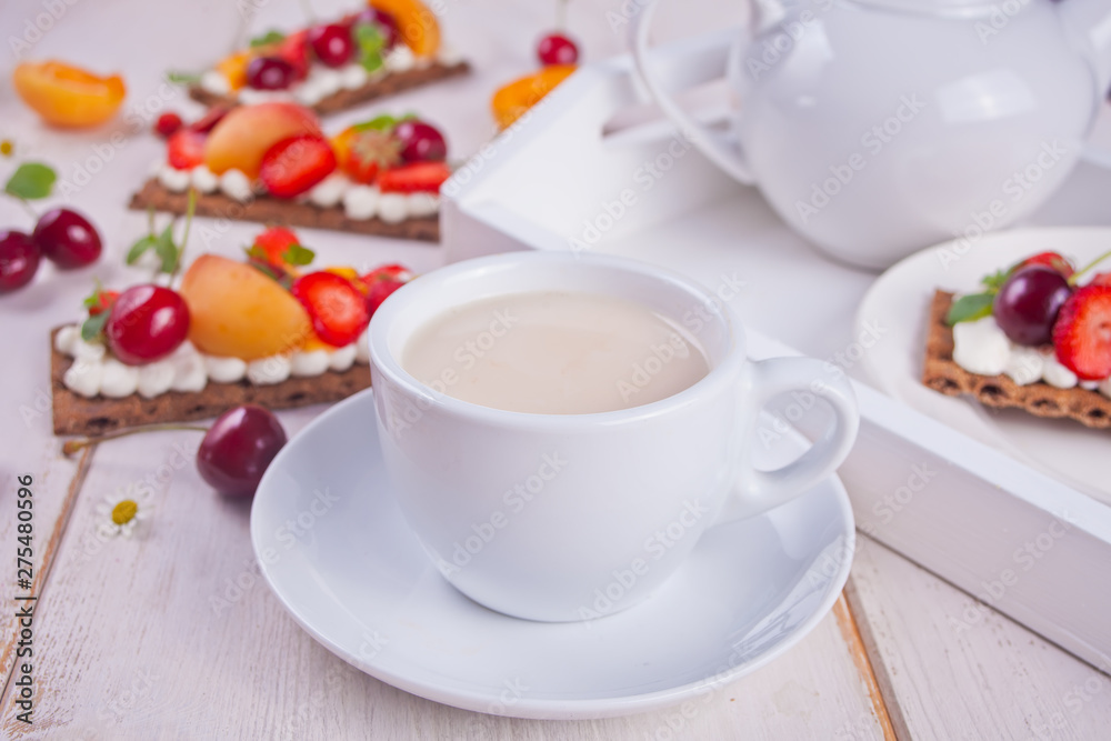 Cup of tea and crisp bread with creme cheese, fruit and berries Cup of tea and crisp bread with creme cheese, fruit and berries