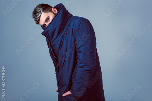 Bild auf Leinwand Model in blue down jacket on a blue background