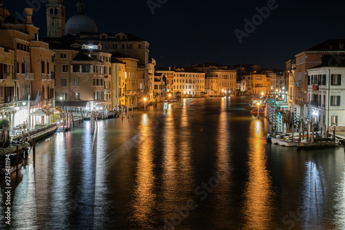 Night photo from the Rialto bridge in Venice  Italy. Overview of the  Riva del Ferro  and view of the Grand Canal illuminated by reflections on the water. View on the Vaporetti pier.