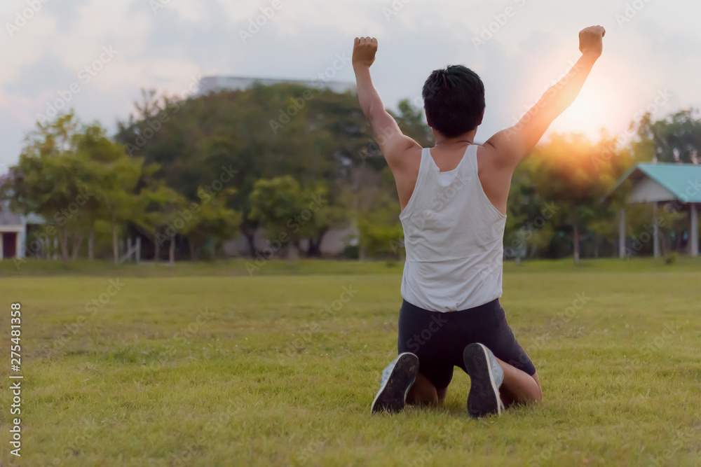 Male athletes celebrated their goals with arms raised and knelt down on the football field at the stadium. Male athletes celebrated their goals with arms raised and knelt down on the football field at the stadium.