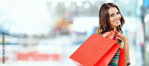 Picture of happy beautiful girl with color shopping bags, at mall photo