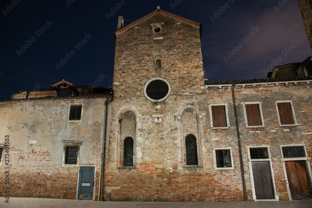 Night photography of the apse of the church of San Giacomo dell'Orio in the Santa Croce district in Venice, Italy. Typical old Venetian houses.