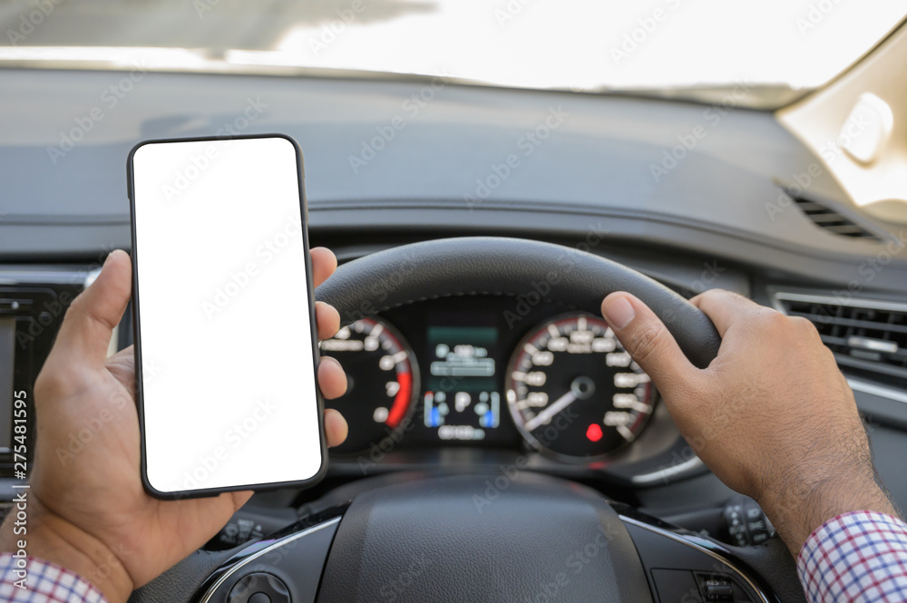 Hand holding blank screen of smartphone while driving car.