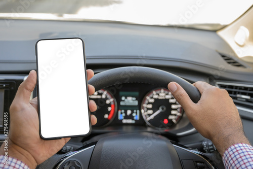 Hand holding blank screen of smartphone while driving car. © Nopphon