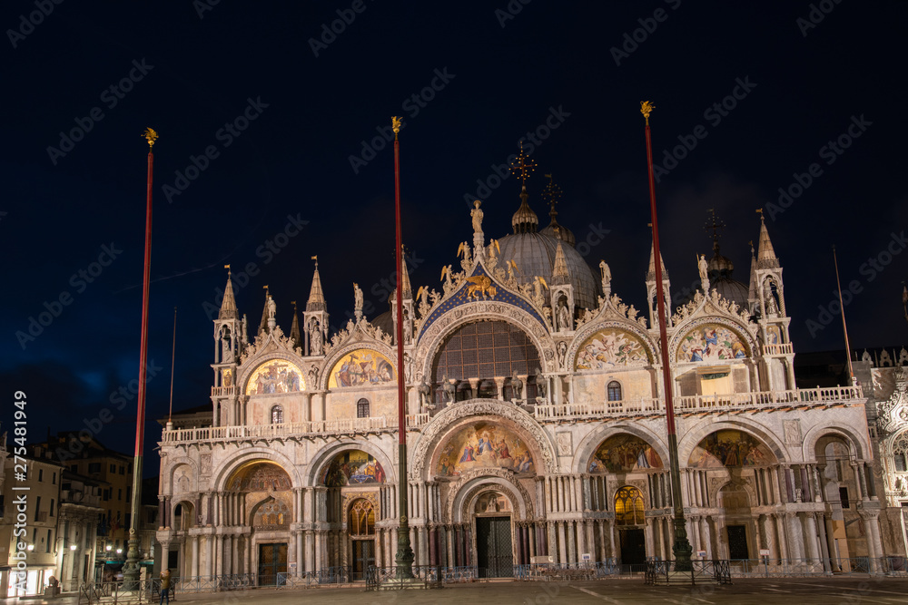 Night photography of the Basilica of San Marco, Venice, Italy. View of the facade with gold mosaics and cupole.