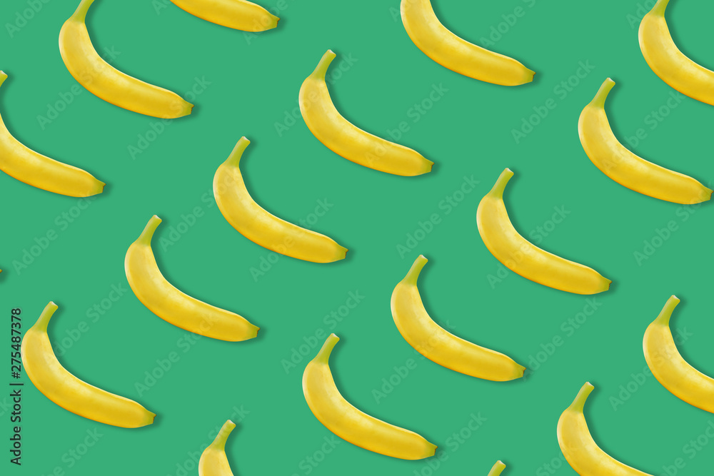 colourful fruit pattern of fresh yellow bananas on colored background