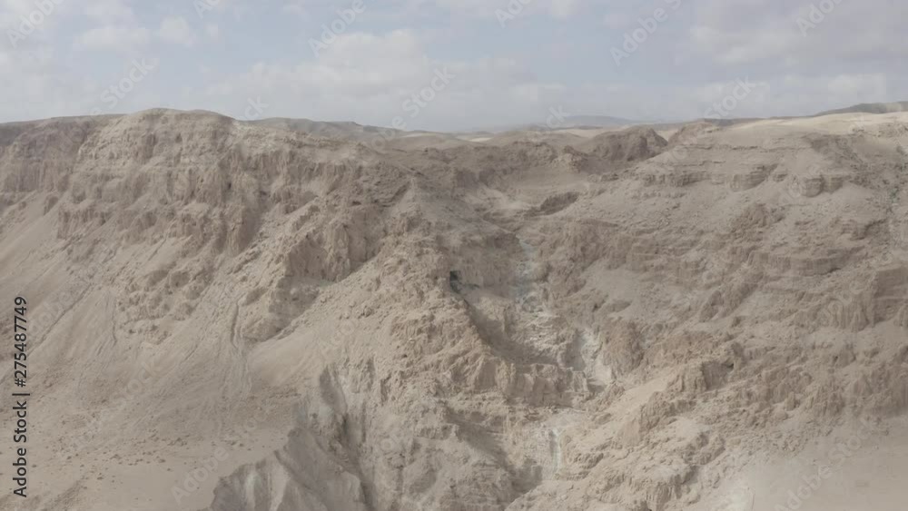 Drone flies over the barren moon landscape of the Israeli desert Negev. The rugged cliffs and the radiant desert sun make this landscape look like something from another world Drone flies over the barren moon landscape of the Israeli desert Negev. The rugged cliffs and the radiant desert sun make this landscape look like something from another world