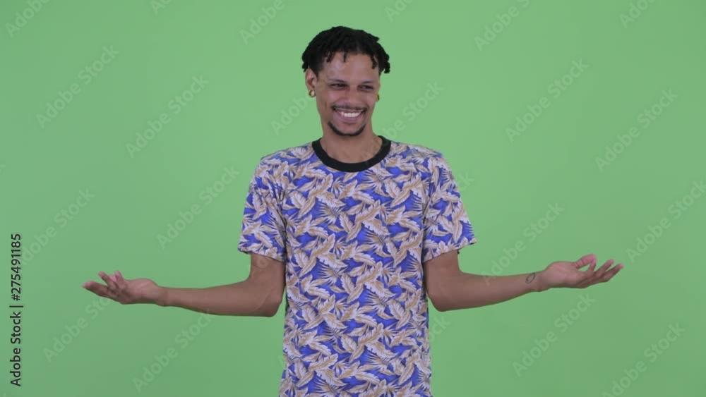 Confused young African man shrugging shoulders