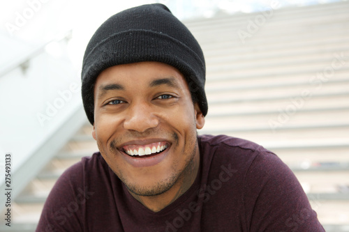 Close up cool young black man with beanie smiling photo