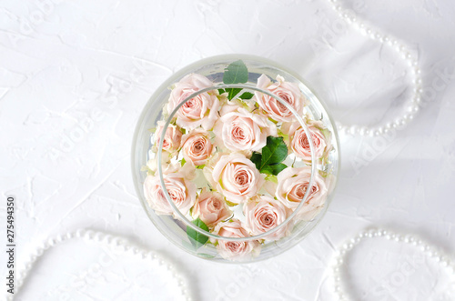 Round vessel with water and small peach roses.