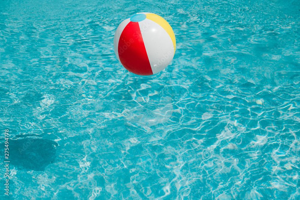 colorful inflatable ball in clean blue water in swimming pool