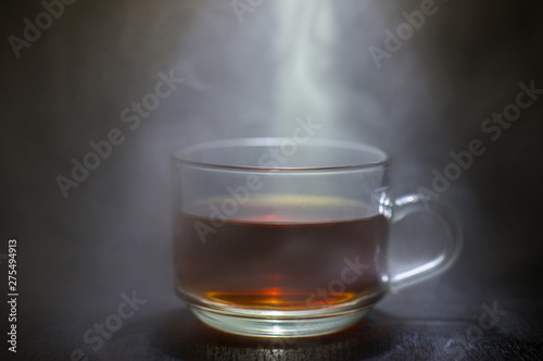 Coffee in a glass with smoke and a black background