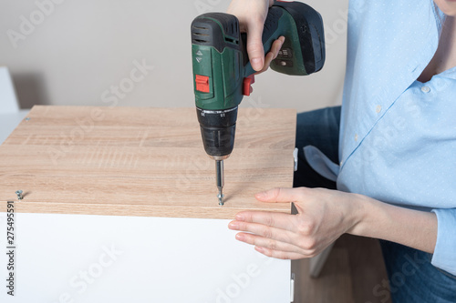 Wallpaper Mural Female hands closeup with a cordless driver collects furniture Torontodigital.ca