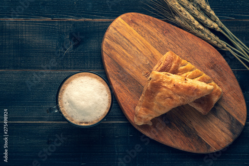 Coffee white cup and croissant for breakfast on wooden background on the table. Perfect breacfast in the morning.