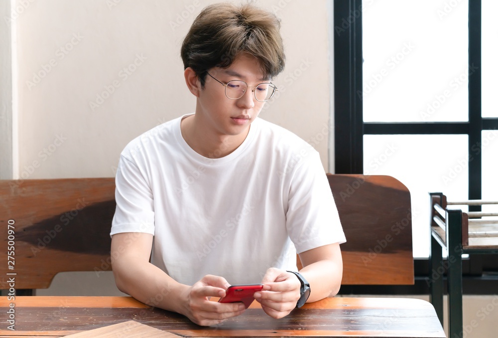 Man wearing his eyeglasses using smartphone asian man touching the smartphone. Man wearing his eyeglasses using smartphone asian man touching the smartphone.