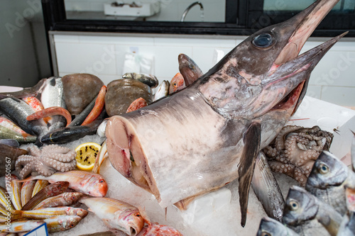 Various fresh seafood and fish displayed on the table for sale in a fish market in Bari, Italy: squids, cuttlefish, octopus, red scorpionfish, sea bream, goatfish