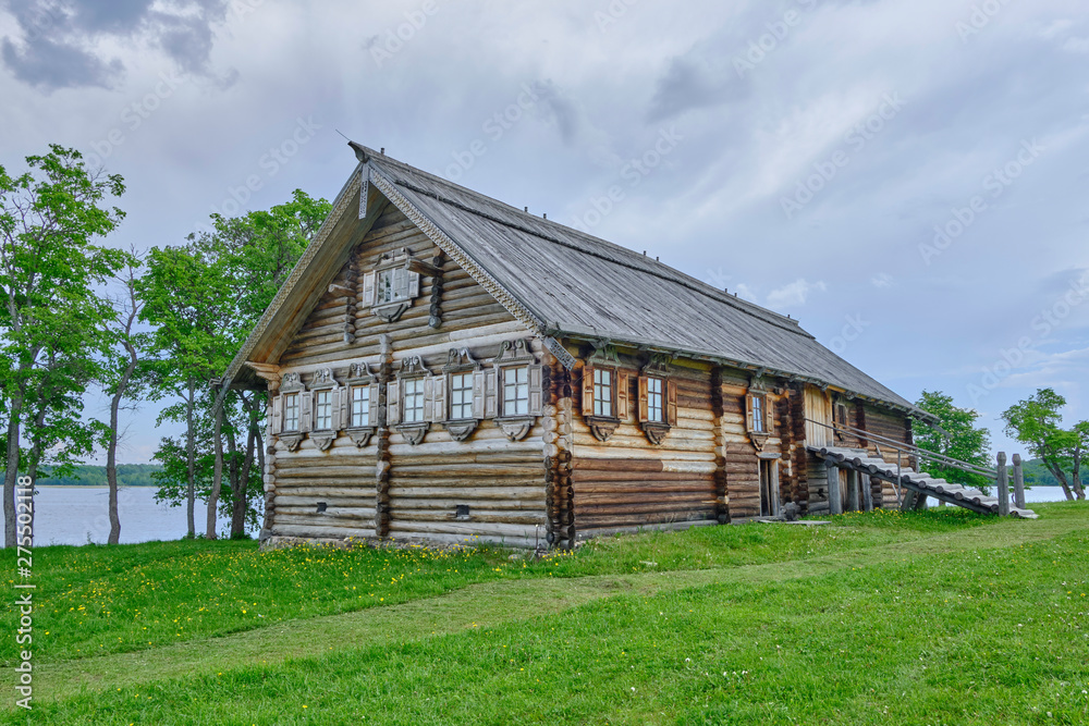 Obraz premium Scenic view of small wooden house on Kizhi island on Onezhsky lake in Russian Federation. Beautiful summer sunny look of traditional building of russian North in Karelia