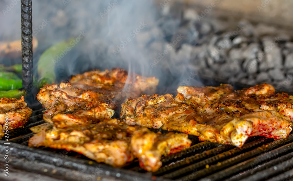 Tasty chicken meat on the grill with fire flames Tasty chicken meat on the grill with fire flames