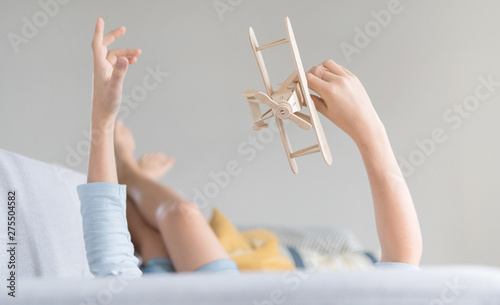 Boy plays with a toy plane on the sofa 3