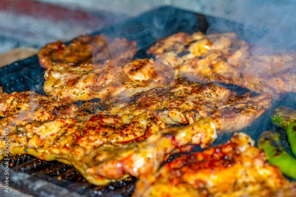 Tasty chicken meat on the grill with fire flames Tasty chicken meat on the grill with fire flames