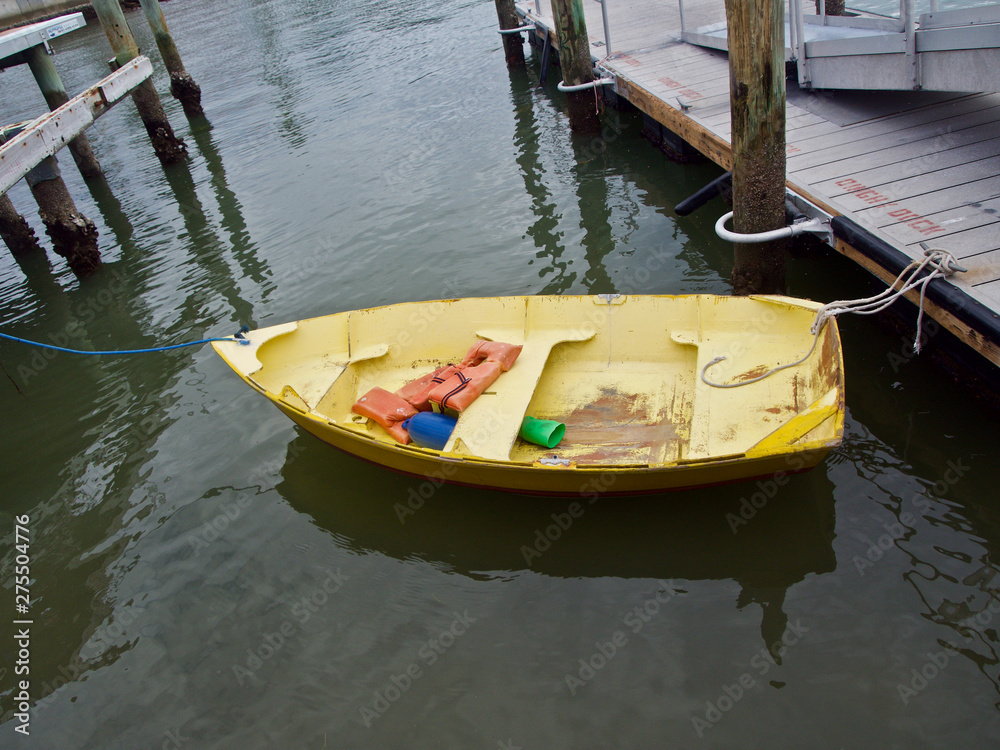 A Weathered Yellow Dinghy Tied to a Dock