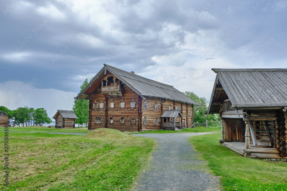 Obraz premium Scenic view of small wooden house on Kizhi island on Onezhsky lake in Russian Federation. Beautiful summer sunny look of traditional building of russian North in Karelia