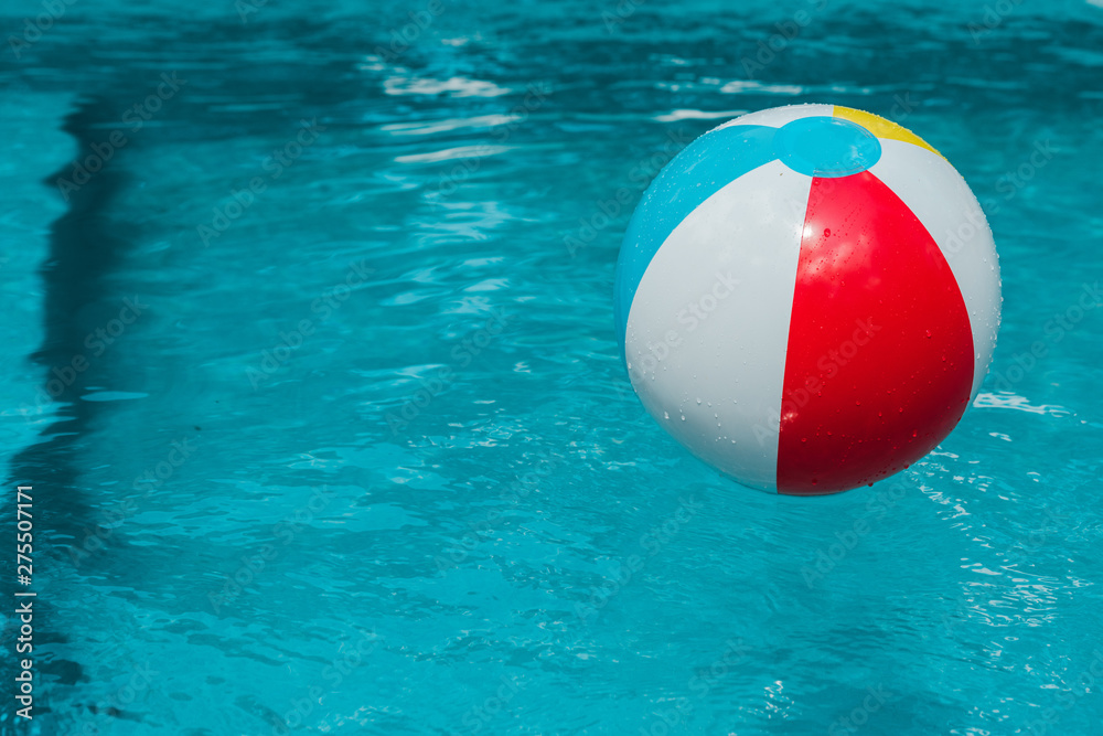colorful inflatable ball in blue water in swimming pool