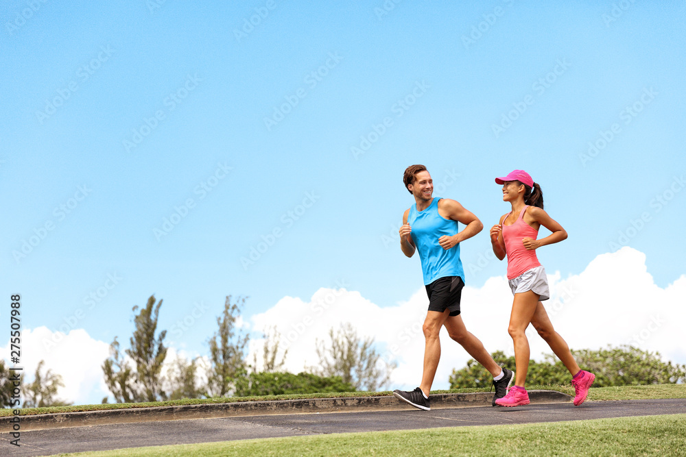 Fototapeta premium Sportowiec biegacze pasują do osób biegających po ulicy - latem aktywny styl życia para fitness trenująca na świeżym powietrzu.