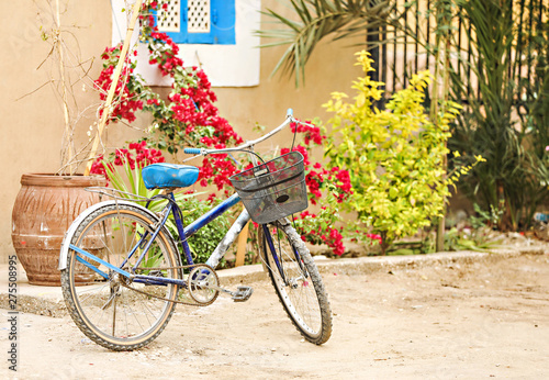 An old bike sitting on a dirt road with colorful background. 