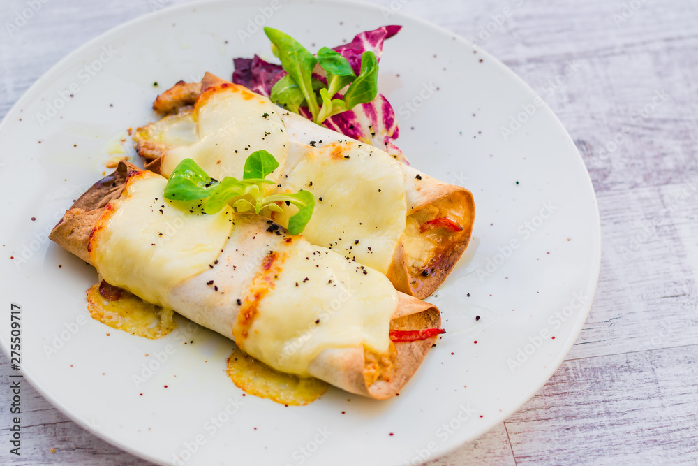 Two beautiful pancakes with ham and cheese decorated with vegetables