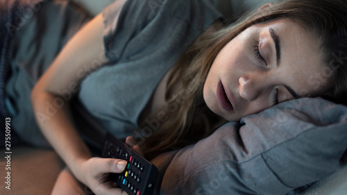 Young girl sleeping while watching tv in the night