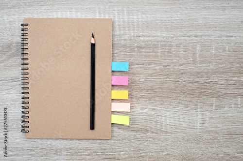 Top view, blank book and pencil on blank book on the wooden table.