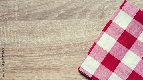 close up top view red color fabric checked tablecloth on vintage wood texture tabletop in kitchen for background design concept 