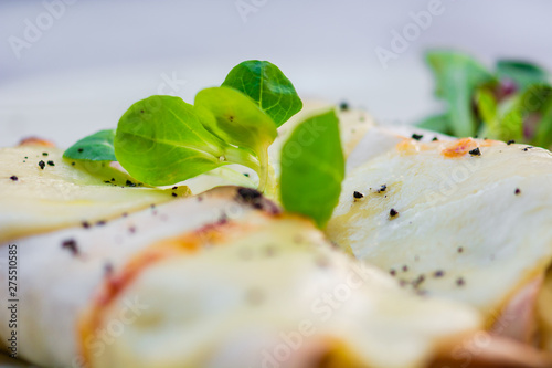 Two beautiful pancakes with ham and cheese decorated with vegetables