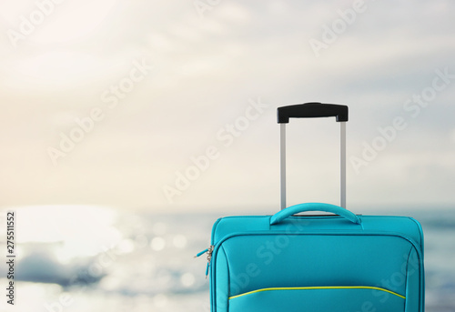 holidays. travel concept. blue suitcase infront of tropical background