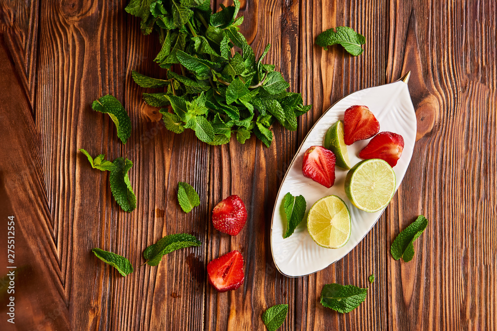 lime strawberry mint ingredients for making lemonade on white plate on wooden table lime strawberry mint ingredients for making lemonade on white plate on wooden table