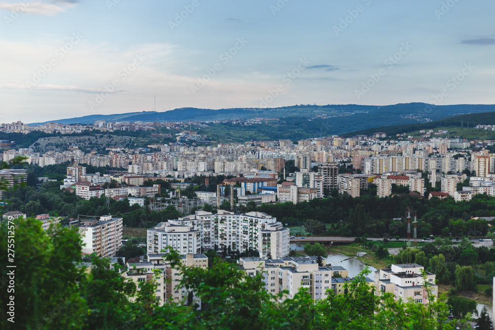 Beautiful city scenery placed in the middle of green hill and with blue sky with clouds on top – Urban settlement surrounded by nature with copy space