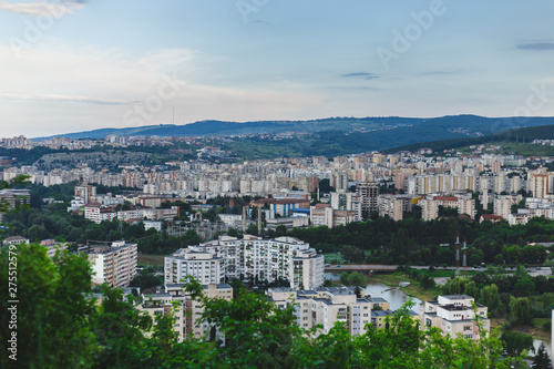 Beautiful city scenery placed in the middle of green hill and with blue sky with clouds on top     Urban settlement surrounded by nature with copy space