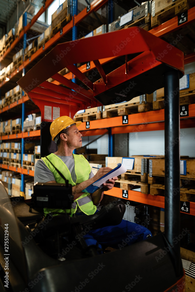 Forklift operator examining stock of packages on shelves in a warehouse. Forklift operator examining stock of packages on shelves in a warehouse.
